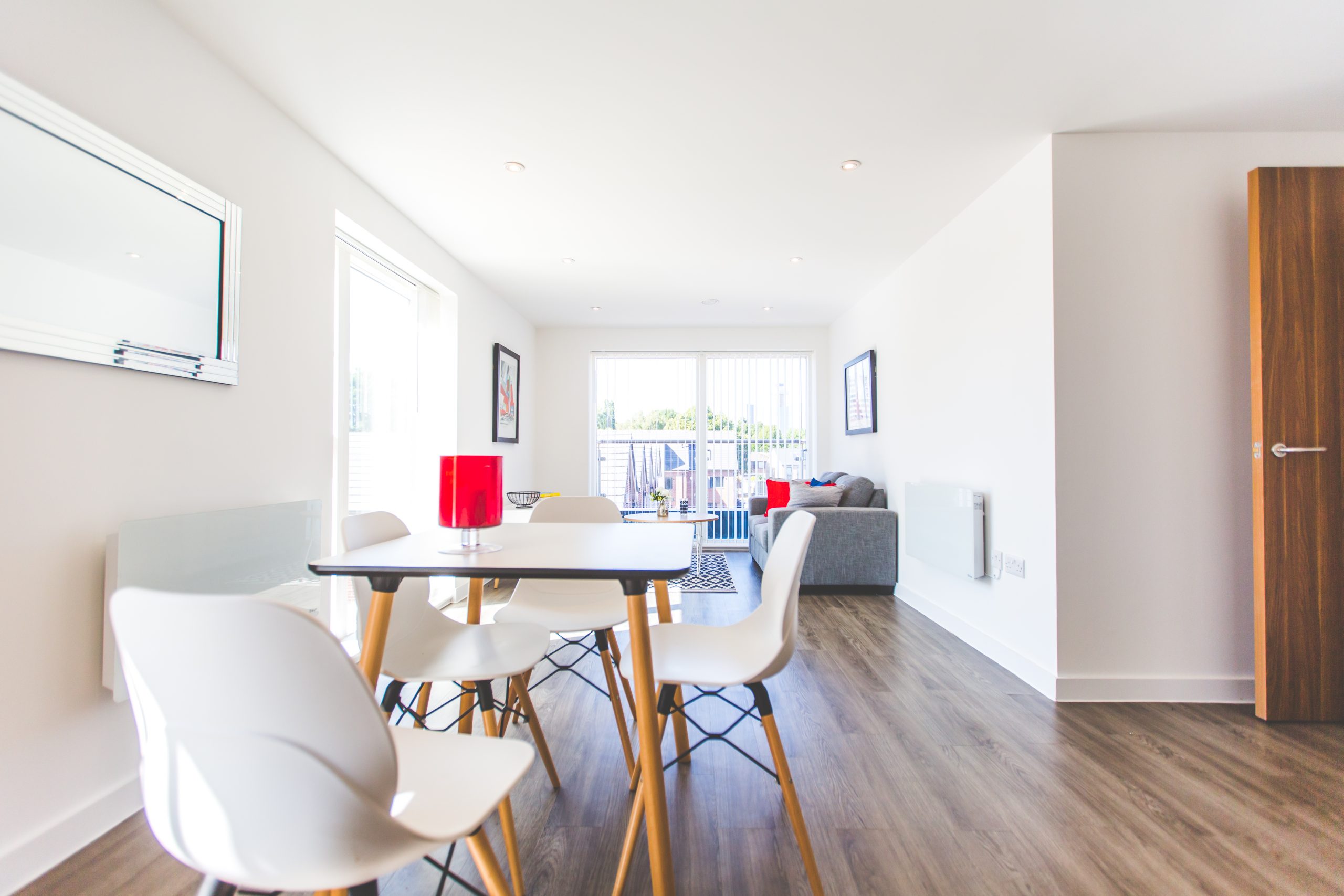 Close up view of a white table and chairs in a bright white apartment.