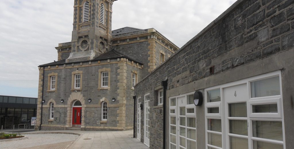 View of the Court House from a distance with a red door and central tower.
