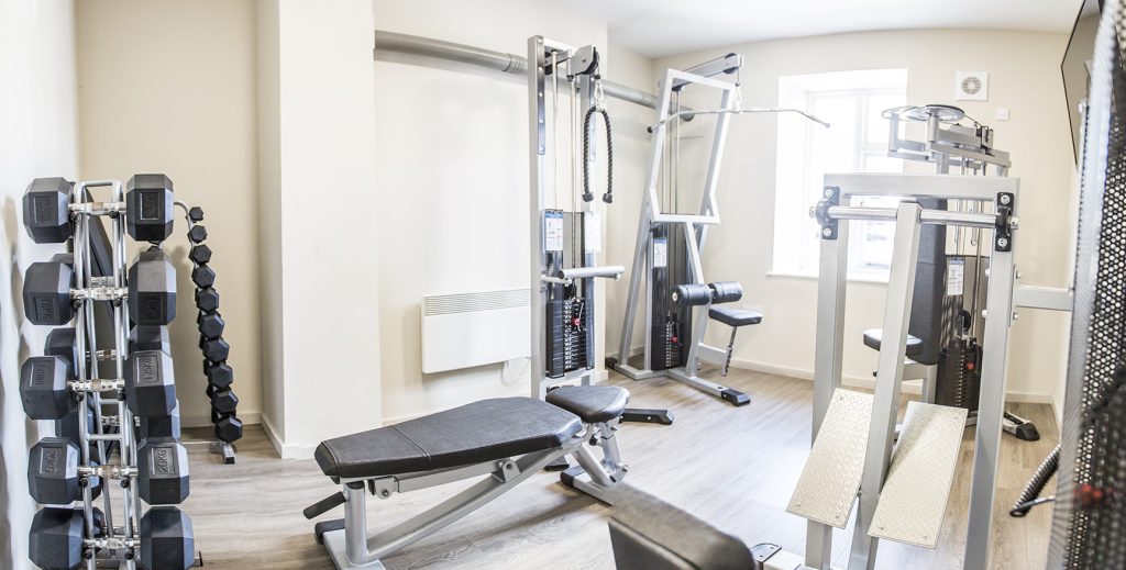 Court House gym with weights and weight benches.