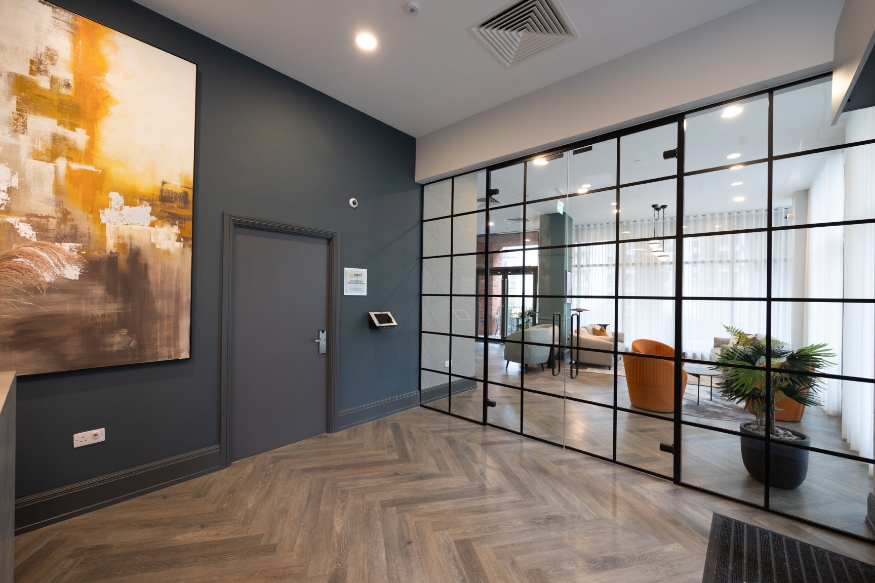 Reception area with glass window looking on to communal area.