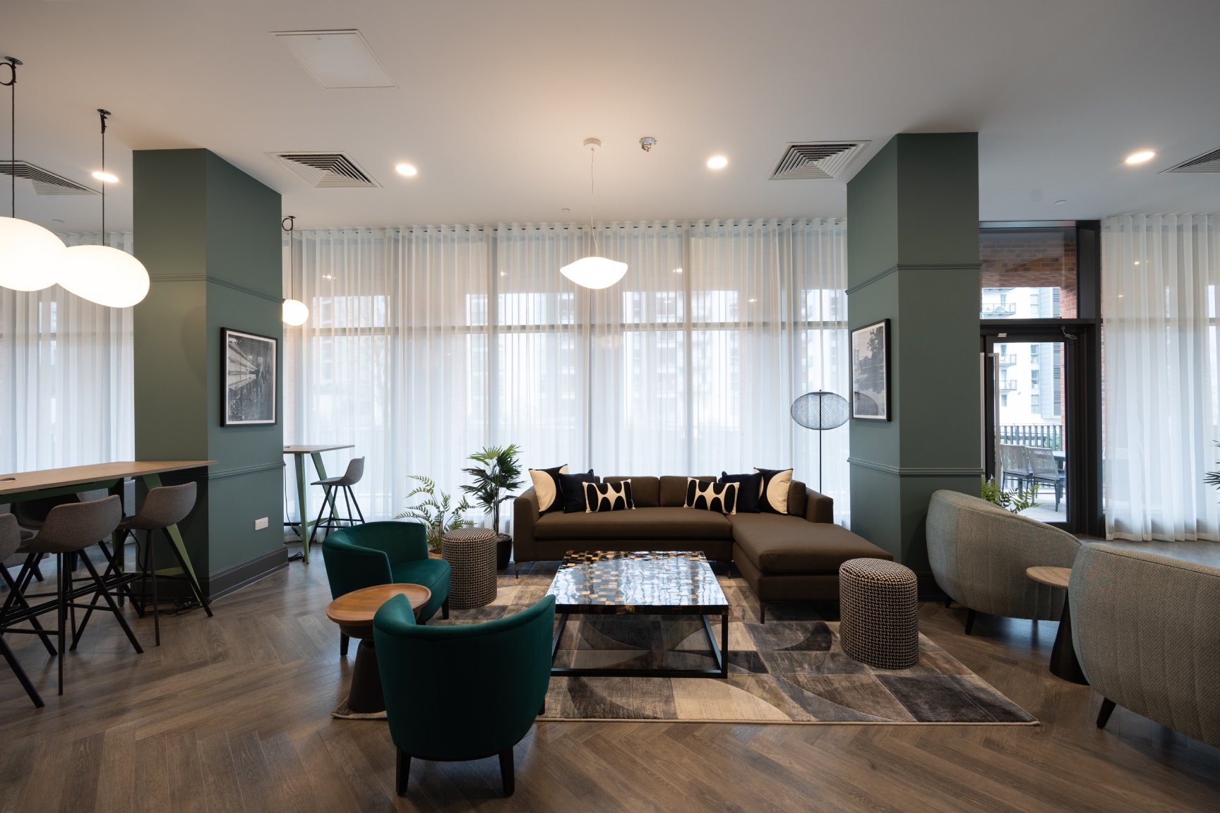 Communal seating area with mixed seating and wooden floors.
