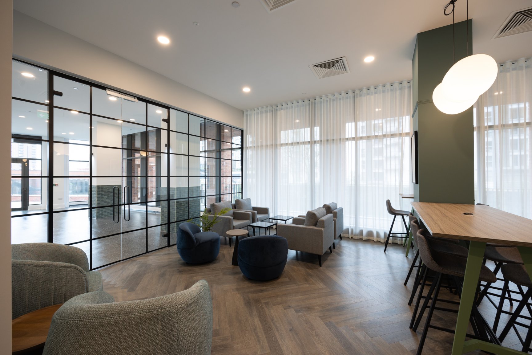 Communal seating area with sofas and high tables and chairs for working.