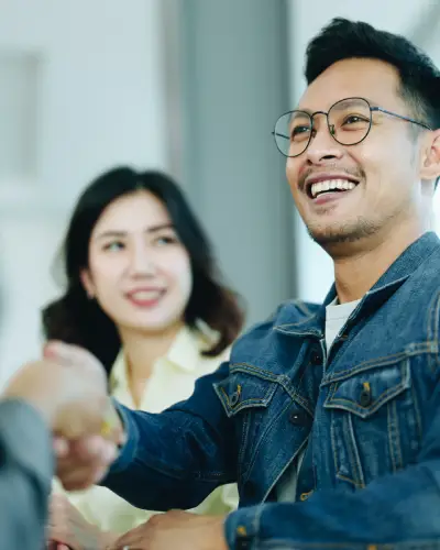 Asian happy landlords shaking property managers hand.