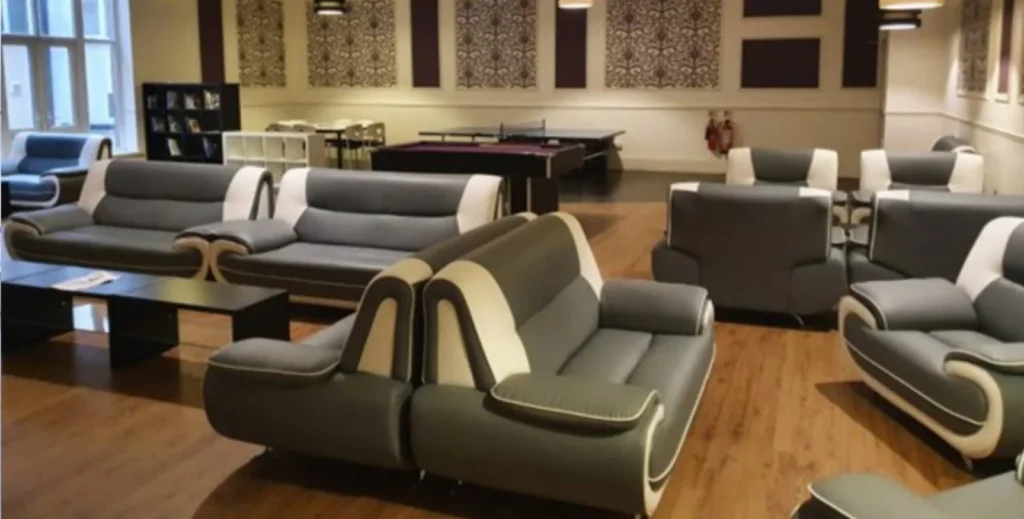 Modern leather sofas positioned within a large communal area.