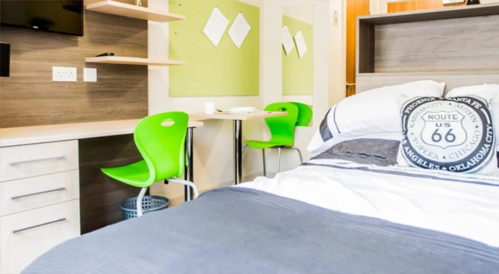 Student room with smart double bed and study area alongside.