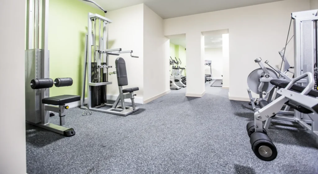 Large gym with multiple pieces of gym equipment.